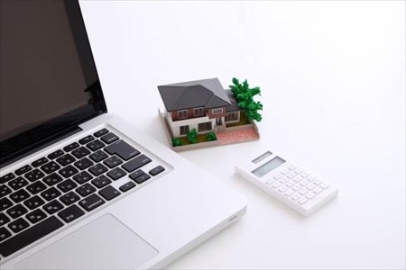 パソコンと電卓と家の模型